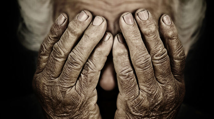 Closeup portrait depressed old woman covering her face with hand