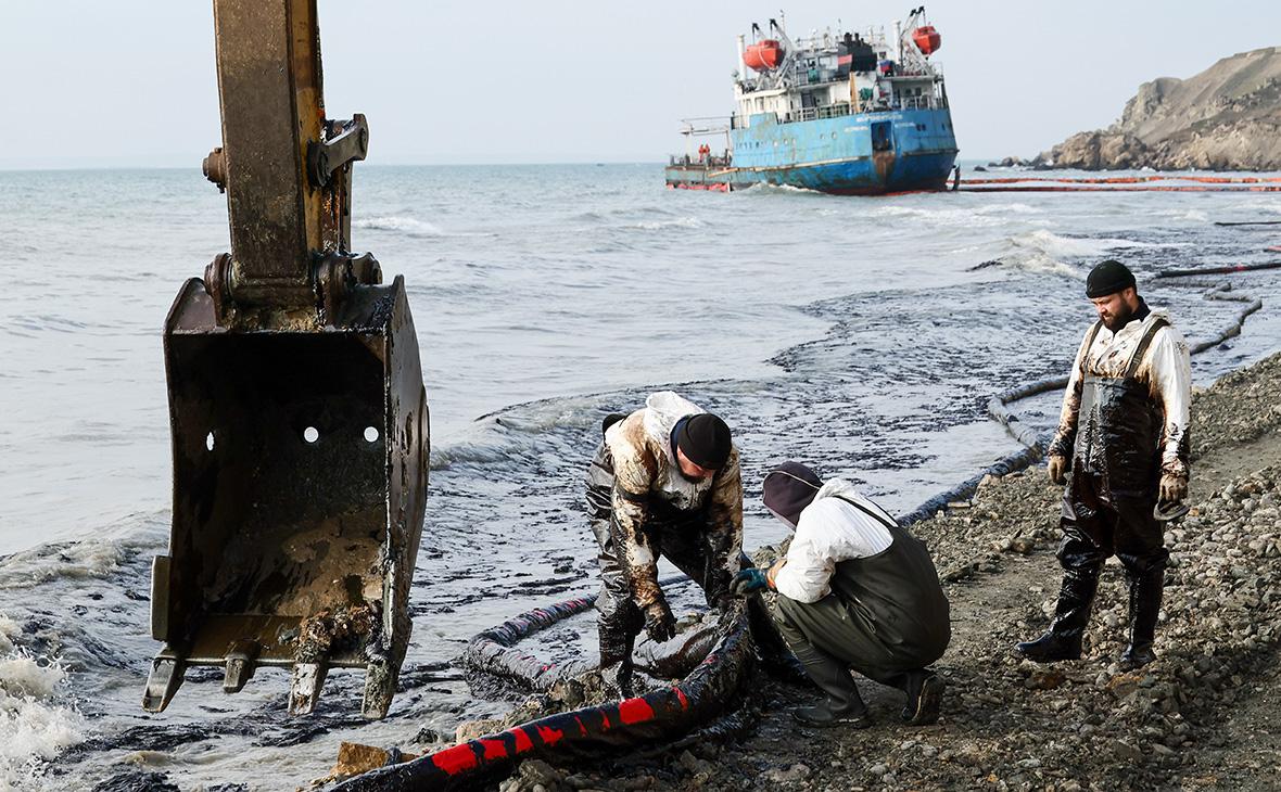 Волонтеры во время ликвидации последствий выброса нефтепродуктов на побережье Черного моря, на дальнем плане   танкер  Волгонефть-239 , поселок Волна, Краснодарский край, январь 2025 года (Сергей Мальгавко / ТАСС)