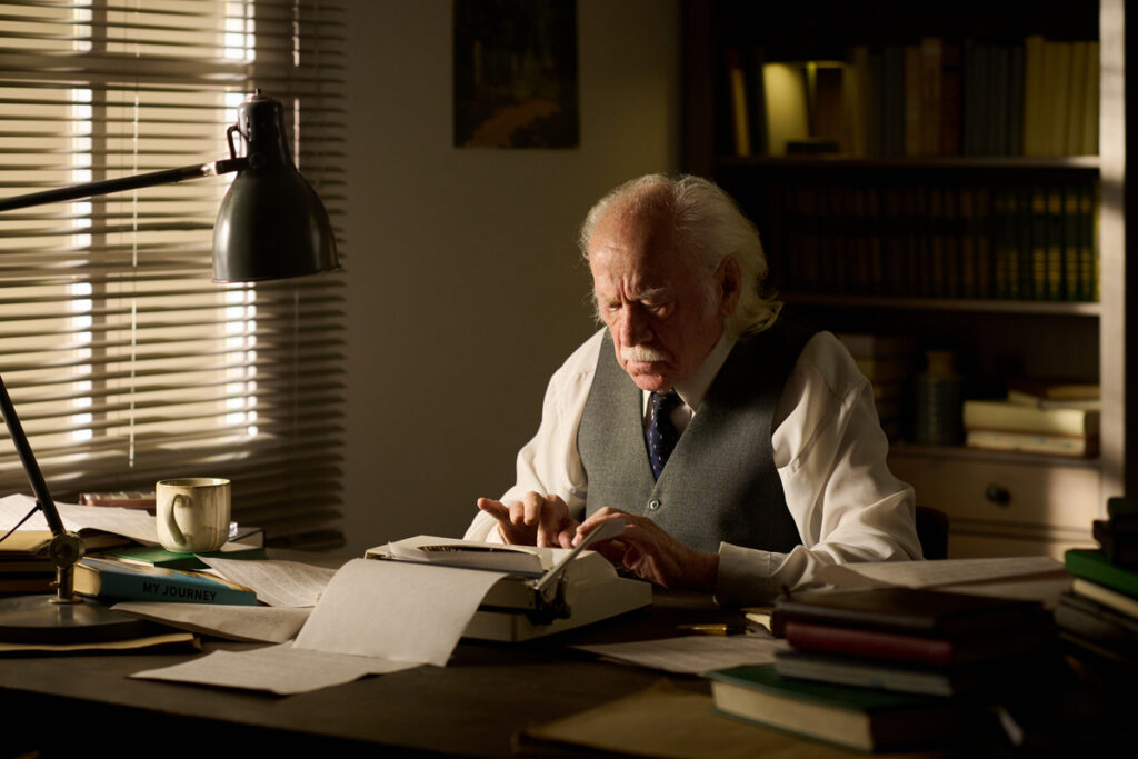 Мужчина пишет мемуары на пишущей машинке