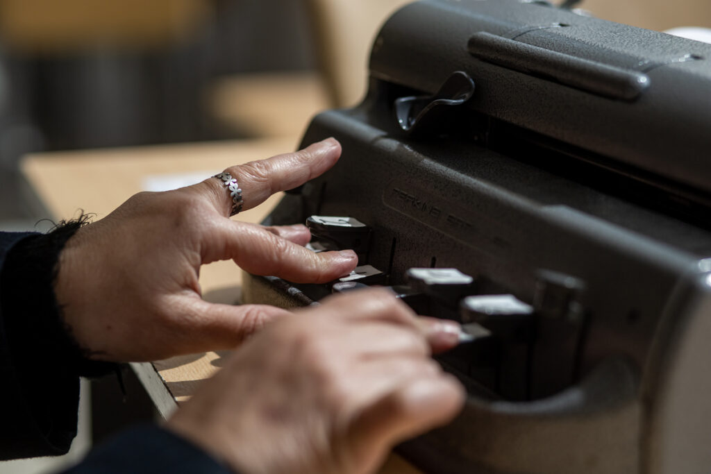 Незрячий человек со станком Брайля