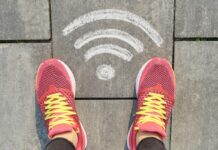 Современные тенденции в компьютерных технологиях Символ Wi-Fi на сером тротуаре с женскими кроссовками