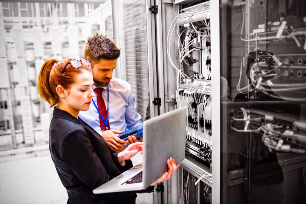 Технические специалисты, использующие ноутбук при анализе сервера