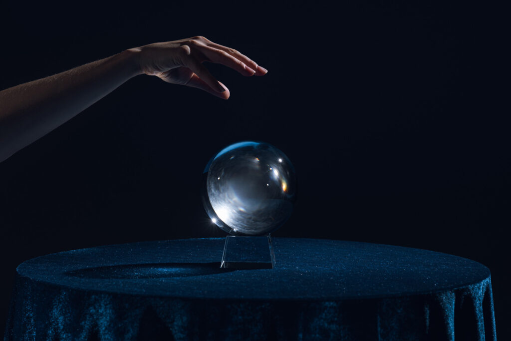 Вид женской руки над хрустальным шаром