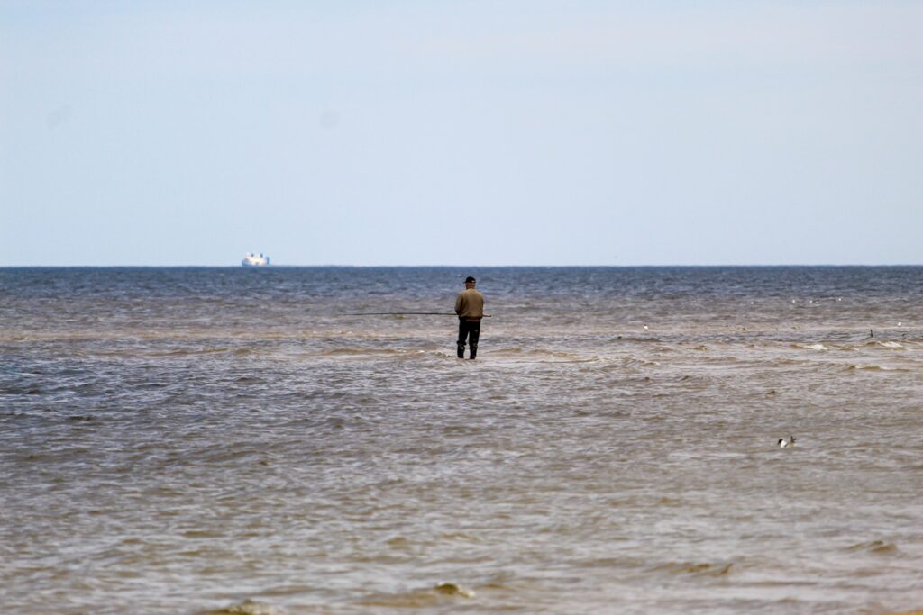 Одинокий человек ловит рыбу в океане
