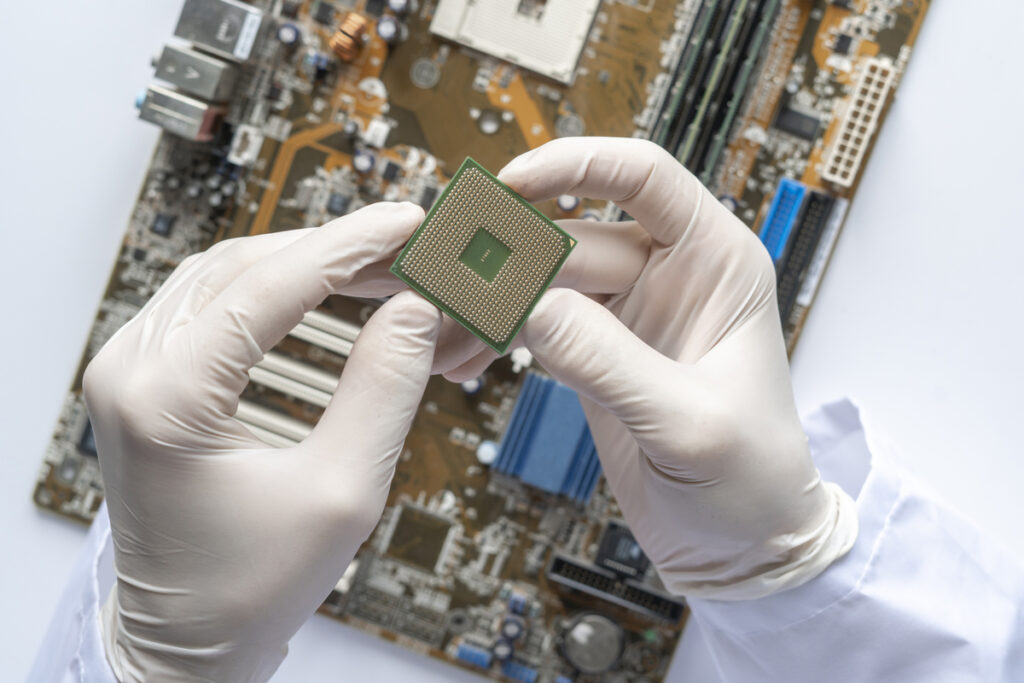 Ученый в перчатках работает с печатной платой