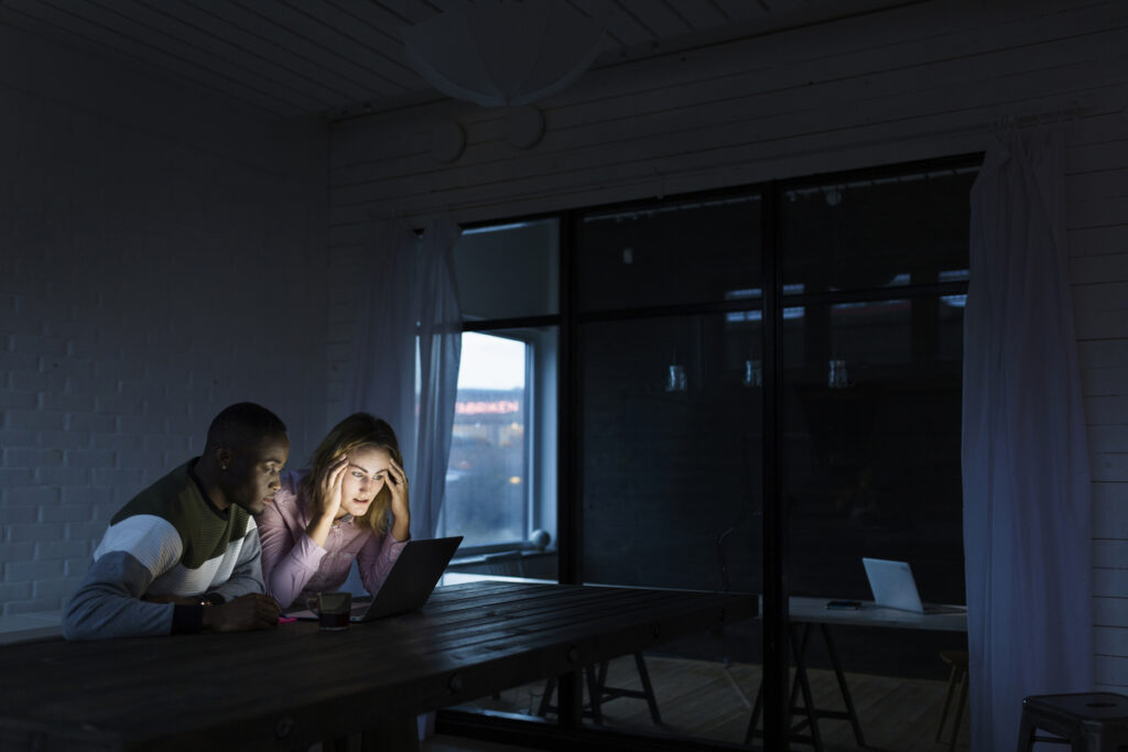 Коллеги, работающие на ноутбуке в темноте