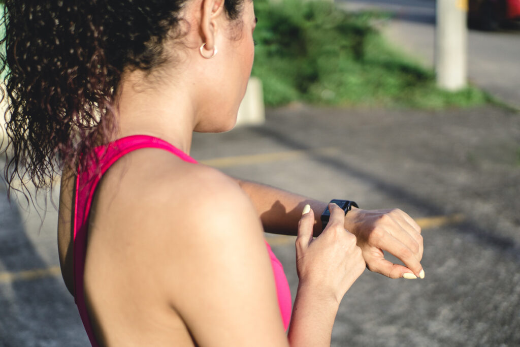 Молодая женщина проверяет время тренировок