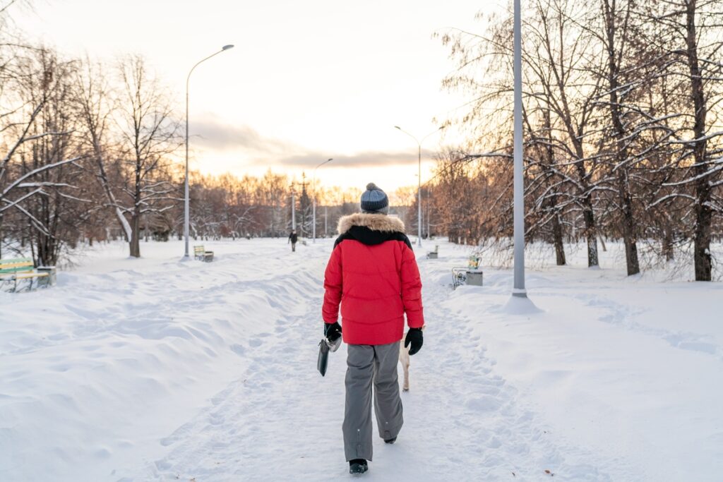 Мужчина гуляет в парке зимой
