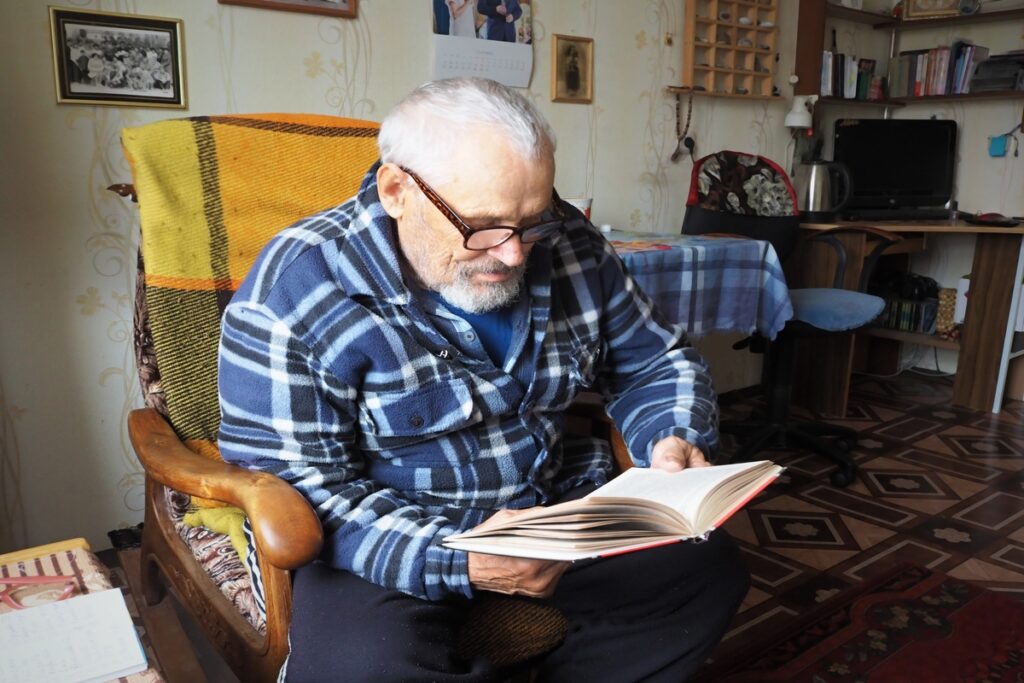 Пожилой мужчина читает книгу