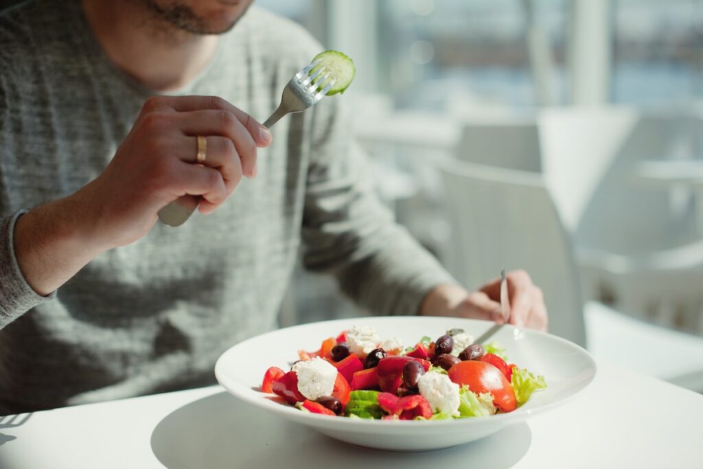Мужчина ест салат