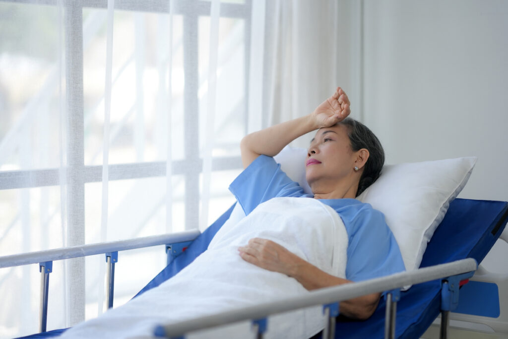 Пациент отдыхает на больничной койке у окна