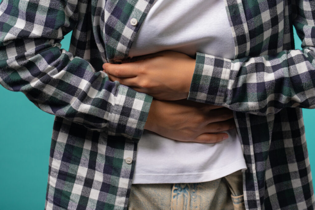 Руки девушки сжимают живот руками