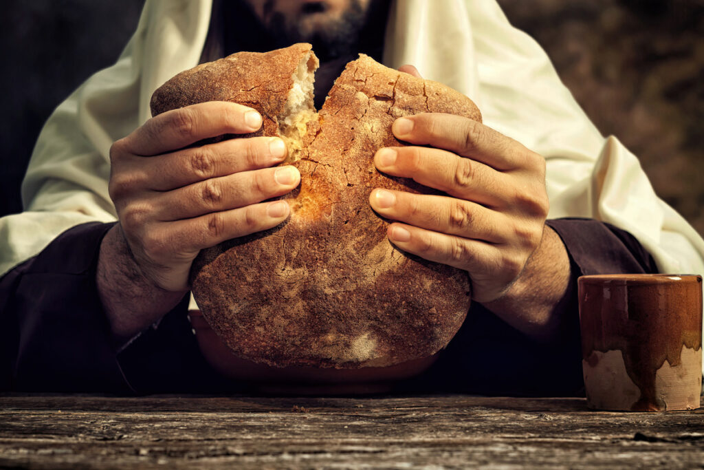 Человек разламывает хлеб