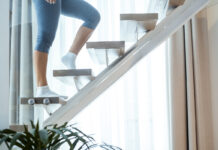 Почему короткие тренировки лучше для здоровья? Женщина поднимается по лестнице