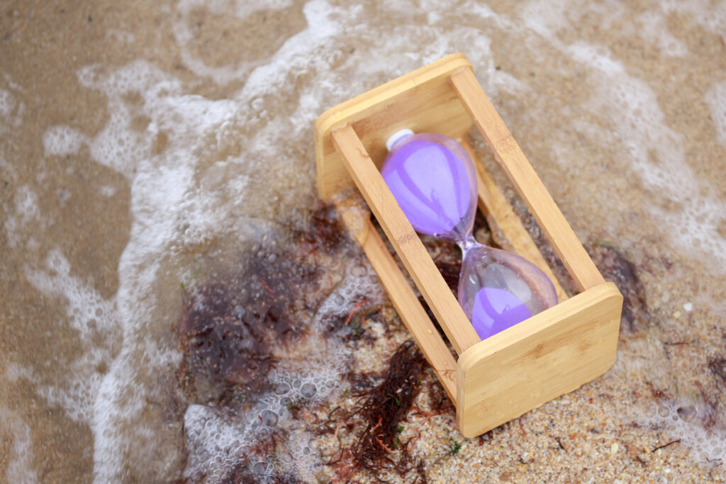 Деревянные песочные часы на пляже
