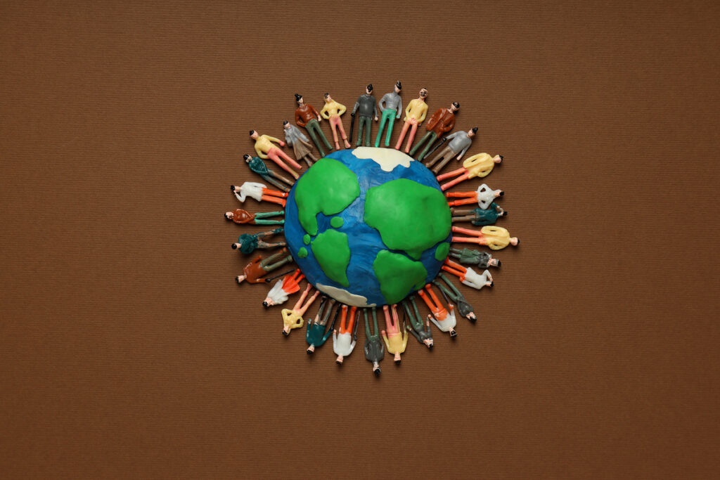 Человечки из пластилина на пластилиновой модели Земли