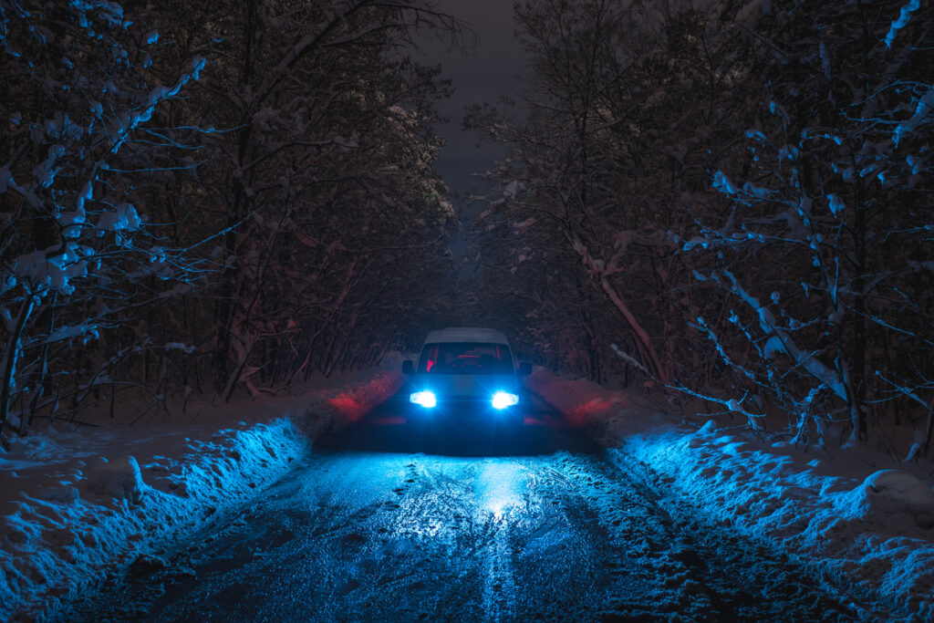 Машина с яркими фарами зимой