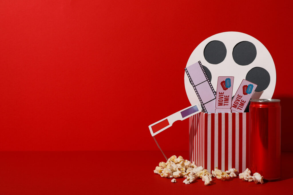 Попкорн, кинолента, билеты, очки и катушка с лентой фильма