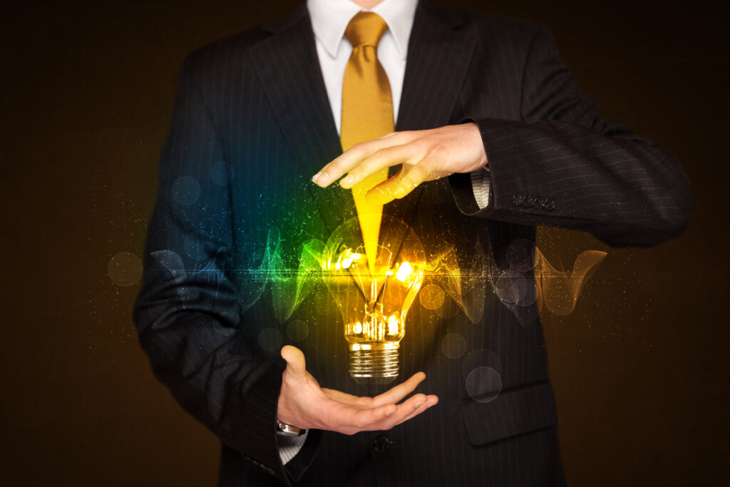 Горящая лампочка в руках бизнесмена