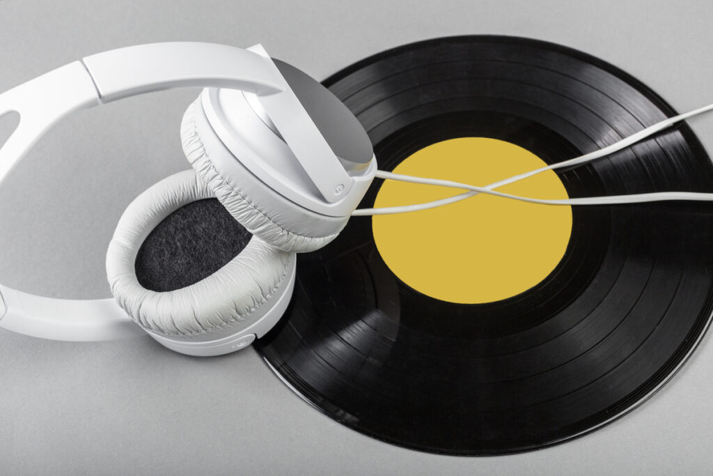 Белые наушники и черная виниловая пластинка