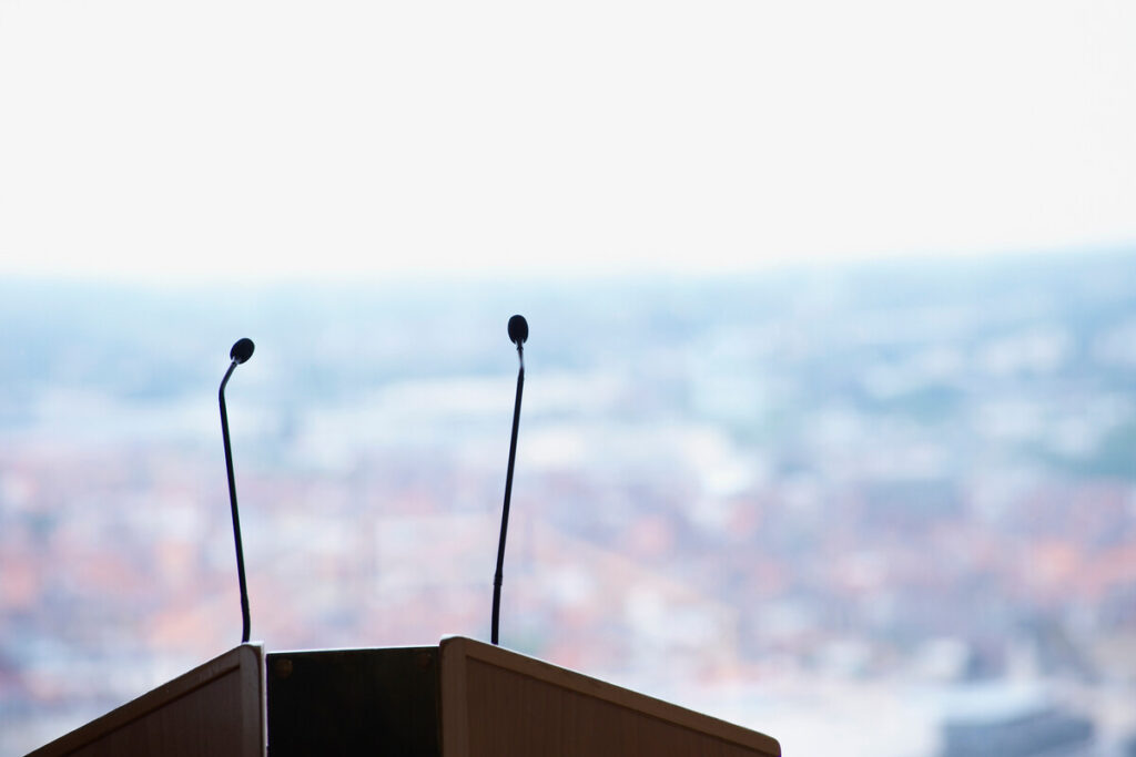 Микрофоны на трибуне с видом на городской пейзаж
