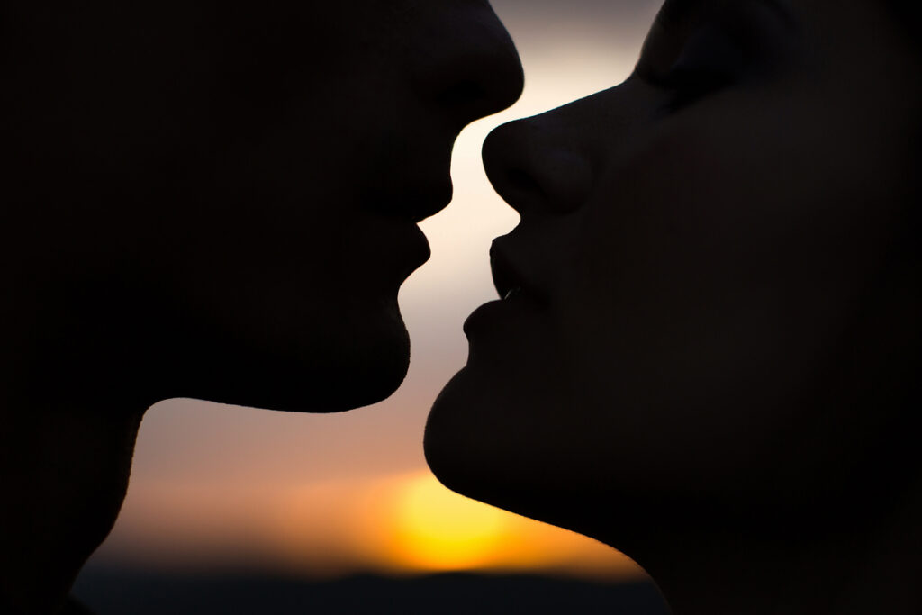 Силуэт целующейся пары на закате
