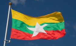 TheNationalFlagOfMyanmarFliesAgainstAClearBlue
