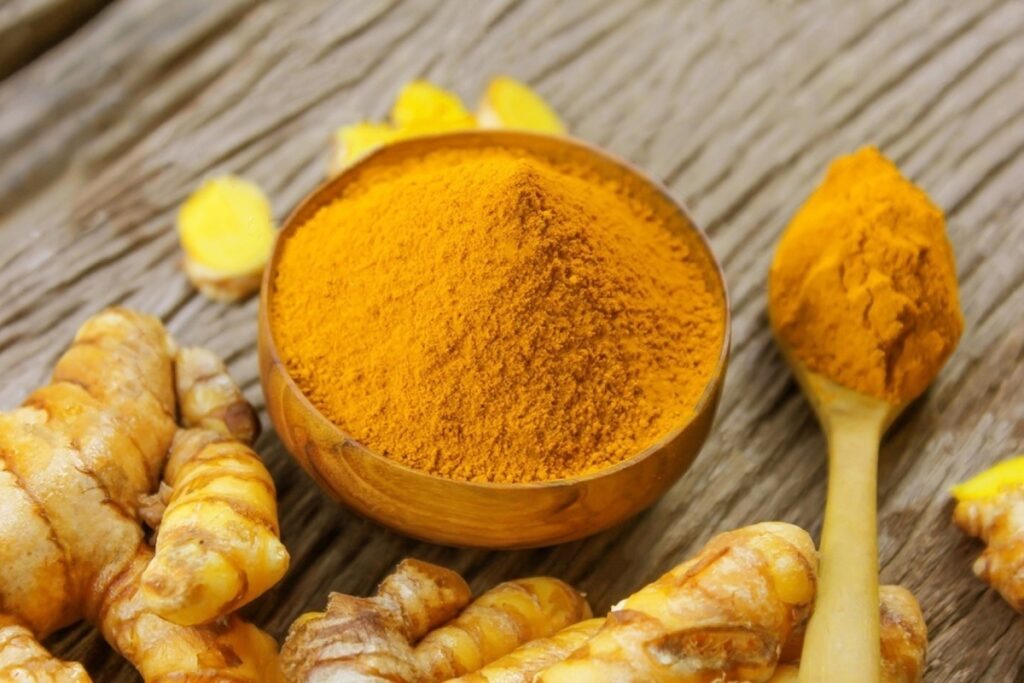 молотая куркума в пиале на деревянном столе