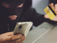 Male,Hacker,In,A,Robber,Mask,Uses,Phone,,Credit,Card