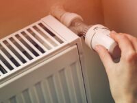 Hand,Adjusting,The,Knob,Of,Heating,Radiator