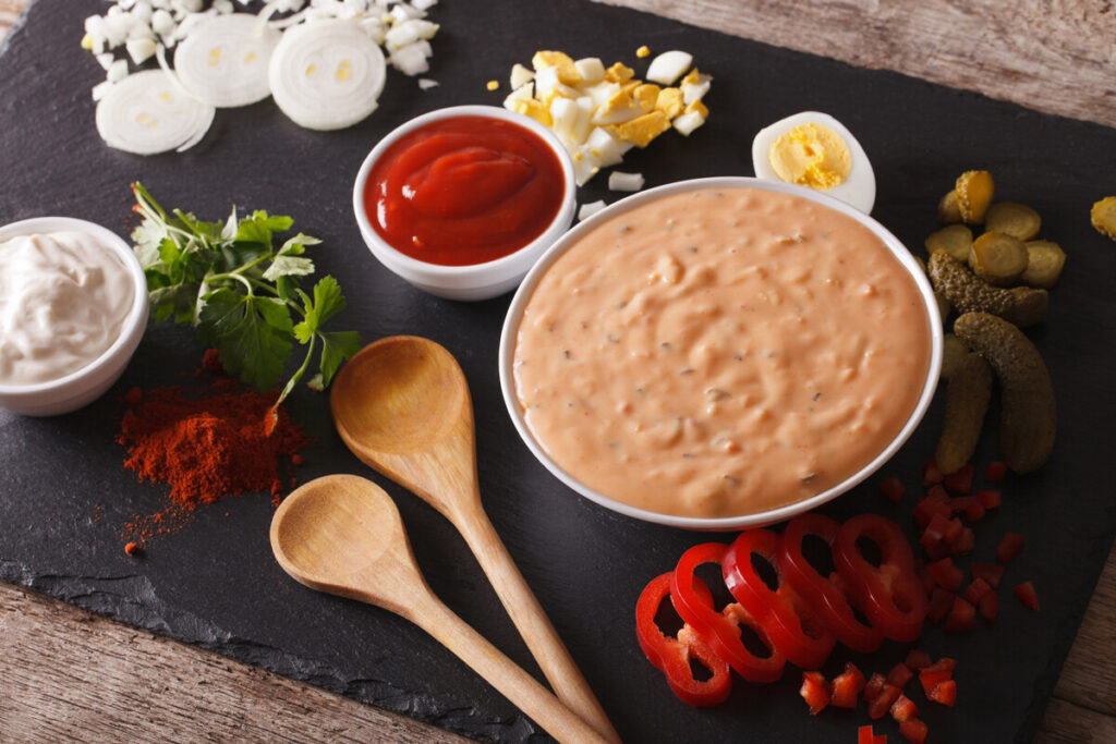 соус в пиале, две ложки и приправы на столе