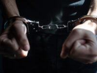Male,Hands,In,Handcuffs,Black,Background