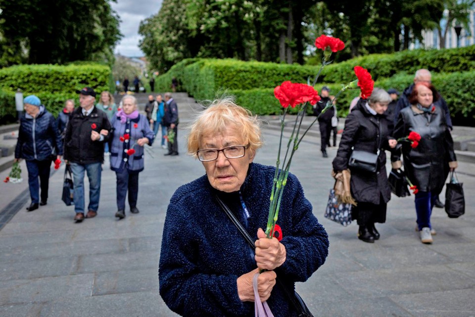 Пожилая бабушка в Киеве пришла к Вечному огню, чтобы возложить цветы.