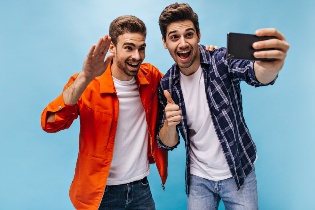два парня фотографируются на телефон