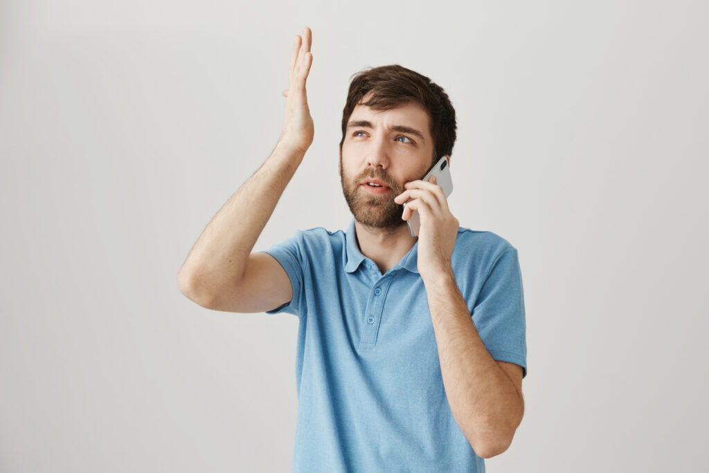 задумчивый парень говорит по телефону