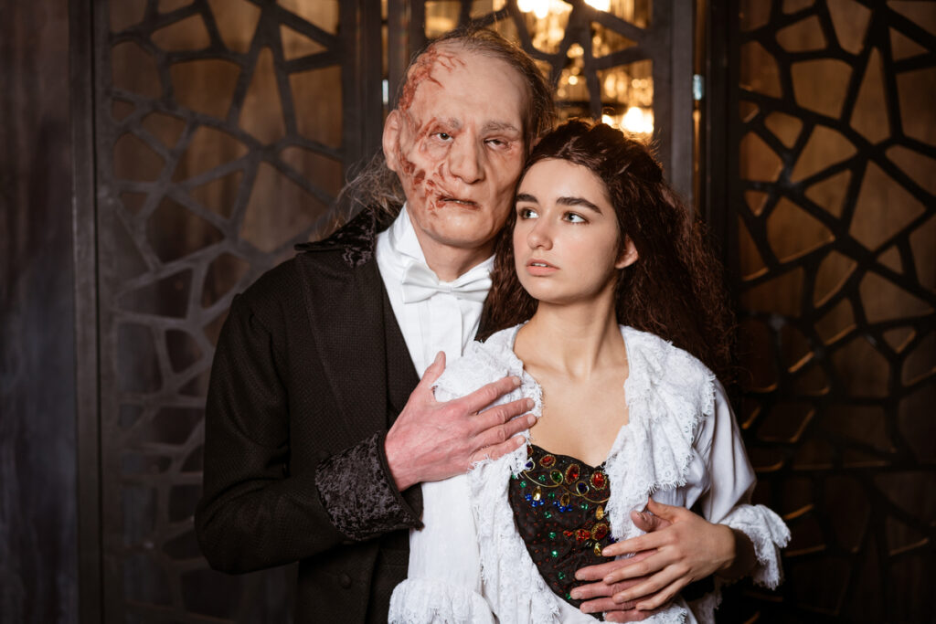 Страшный мужчина обнимает молодую красивую девушку