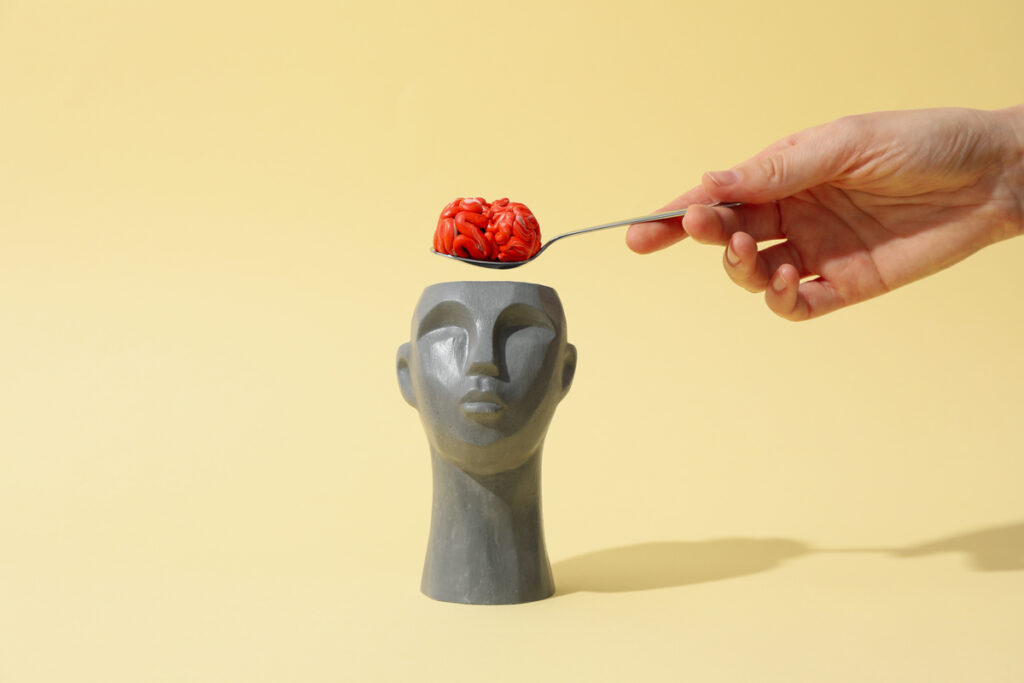 Голова и рука с ложкой и мозгами