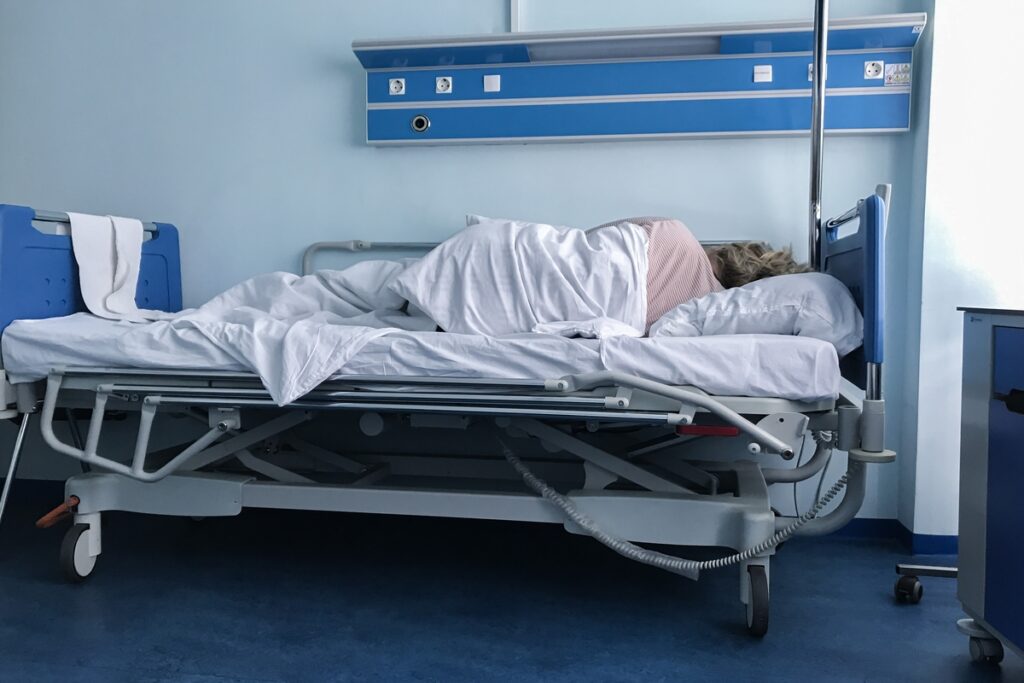 Пациент спит на кровати лицом к стене