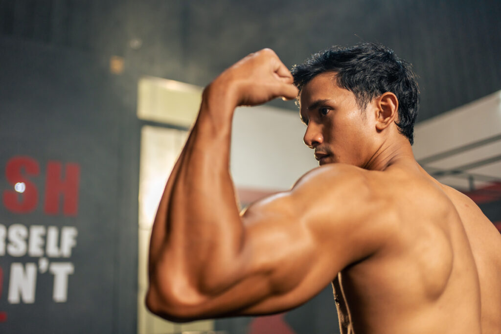 Спортсмен показывает большие мускулы 
