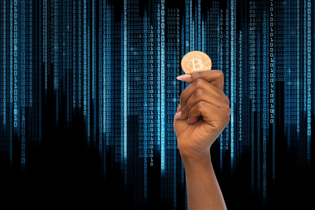 Крупный план женской руки, держащей золотой биткойн
