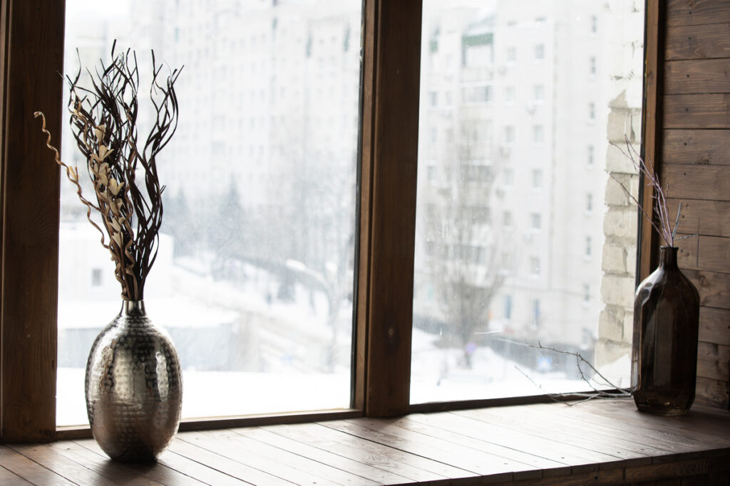 Бутылки с ветками на окне