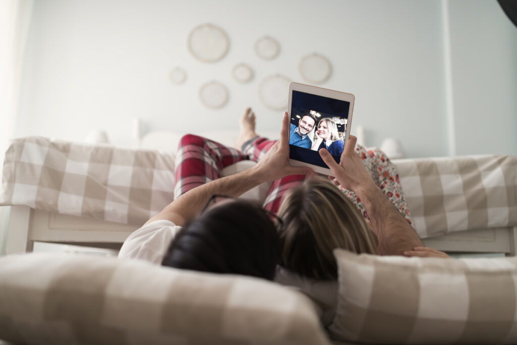 Пара использует планшет в спальне