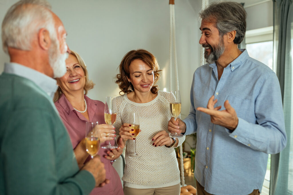 Зрелые люди пьют шампанское
