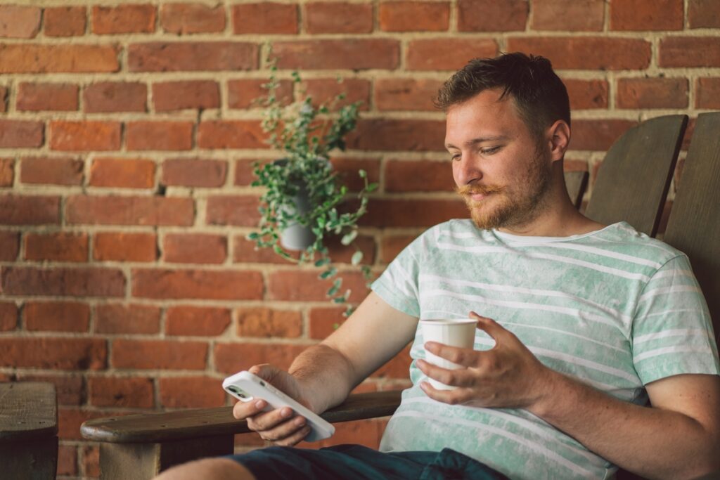 Молодой человек использует мобильный телефон