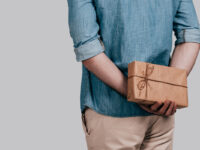 Что подарить человеку, у которого есть всё? Мужчина держит подарок за спиной