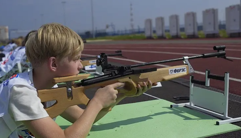 Мальчик пробует стрелять из лазерной винтовки