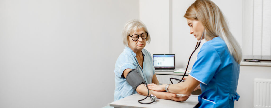Nurse measuring blood pressure of a senior patient - signaldaily медсестра измеряет женщине давление