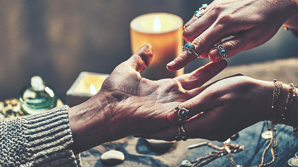 FortuneTellerWomanWearingTurquoiseSilverRingsAndBraceletsReads