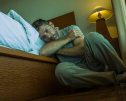 DramaticHomePortraitOfYoungDepressedAndDesperateManSitting