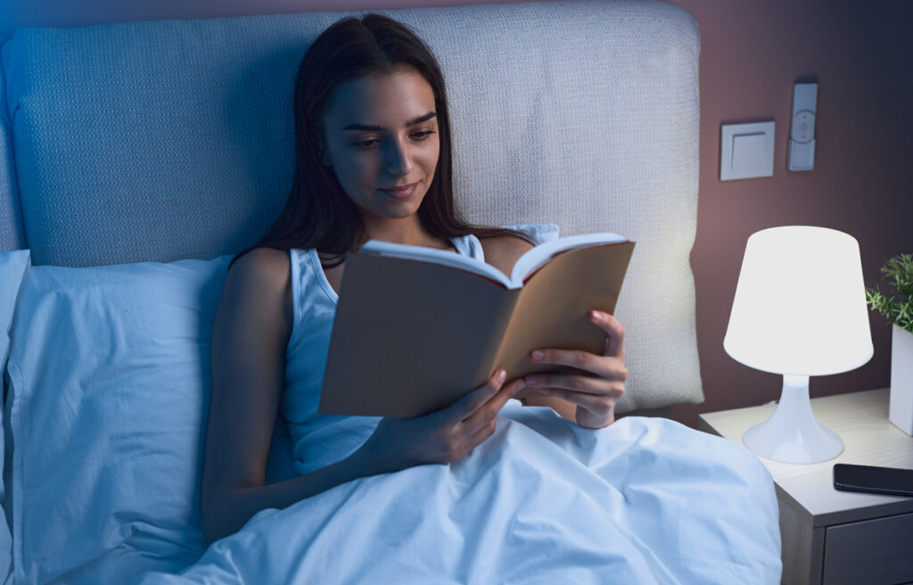 девушка читает книгу ночью в кровати